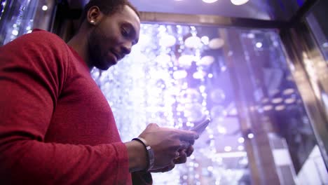 man texting in an elevator at night