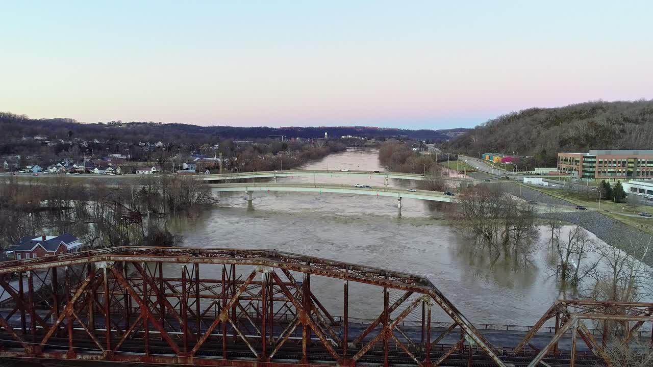 viejo puente abandonado oxidado con vistas a un río inundado en una ciudad rural americana al atardecer