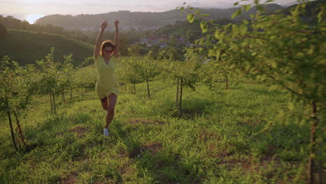 woman running in a orchard at sunset