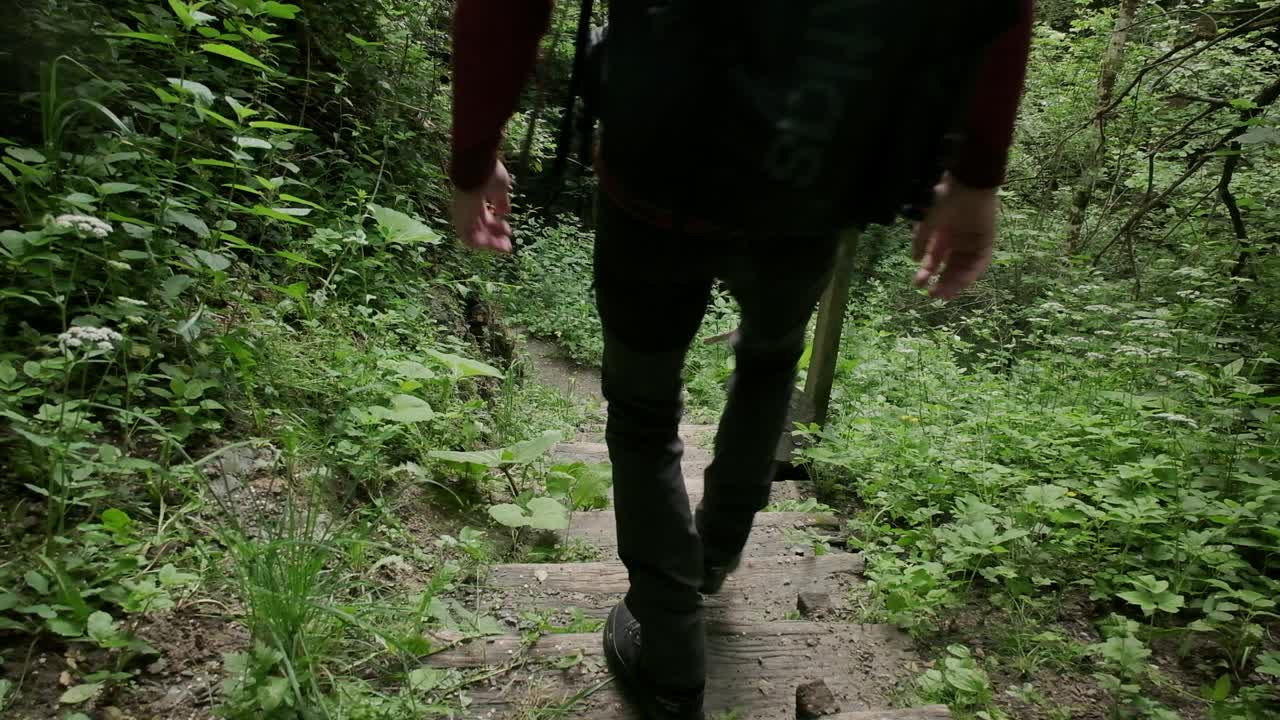 hombre bajando las escaleras con una cámara mochilero en escaleras mojadas