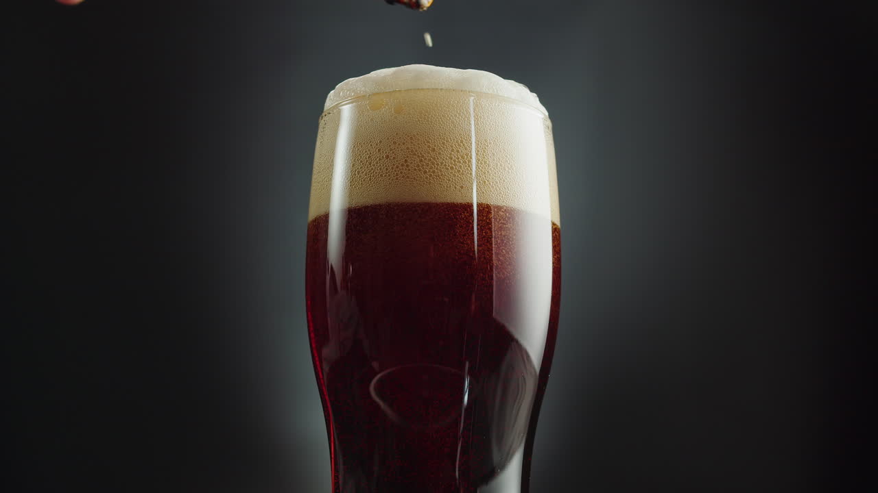 Pouring dark beer into a glass