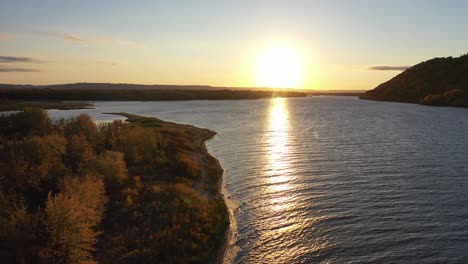 sunset over a river with autumn foliage