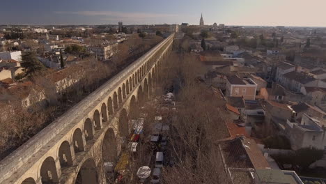 old aqueduct arceaux neighbourhood market time. aerial drone shot morning