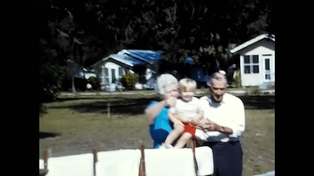 A Man and a Woman Holding a Baby, Captured in 1970s USA. CIRCA USA - 1970s: A heartwarming moment of a man and a woman holding their baby, all captured in a 1970s video from the USA.