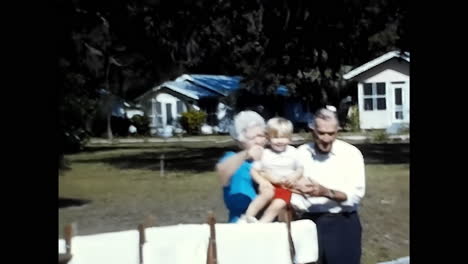 a man and a woman holding a baby, captured in 1970s usa. circa usa - 1970s: a heartwarming moment of a man and a woman holding their baby, all captured in a 1970s video from the usa.