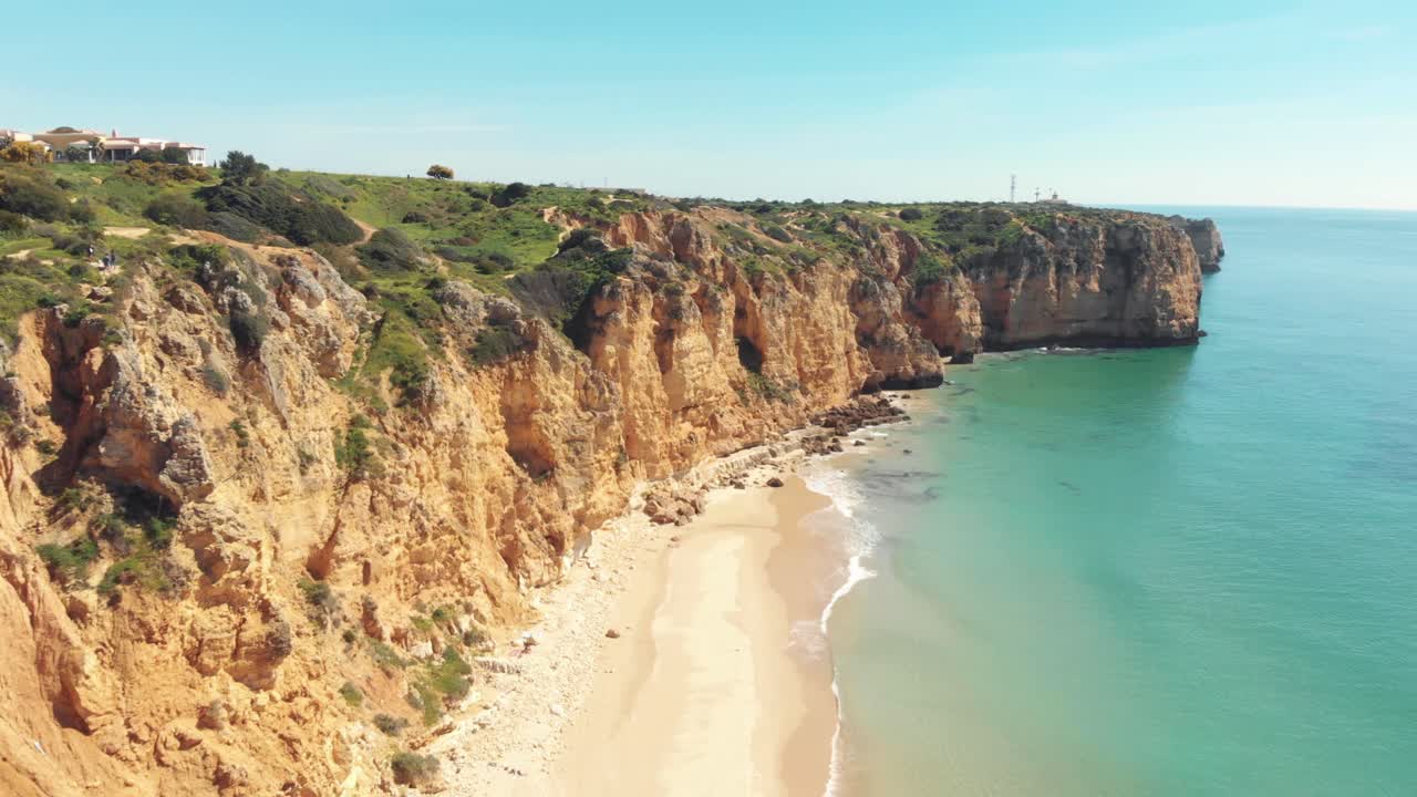 Playa de Canavial enmarcada por acantilados pintorescos en Lagos, Algarve, Portugal - Toma aérea de seguimiento con sobrevuelo