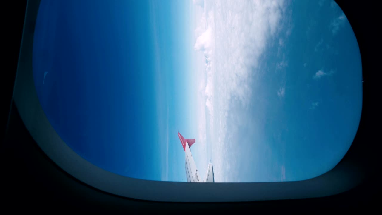 비행기의 창문에서 날개와 구름을 볼 수 있습니다.