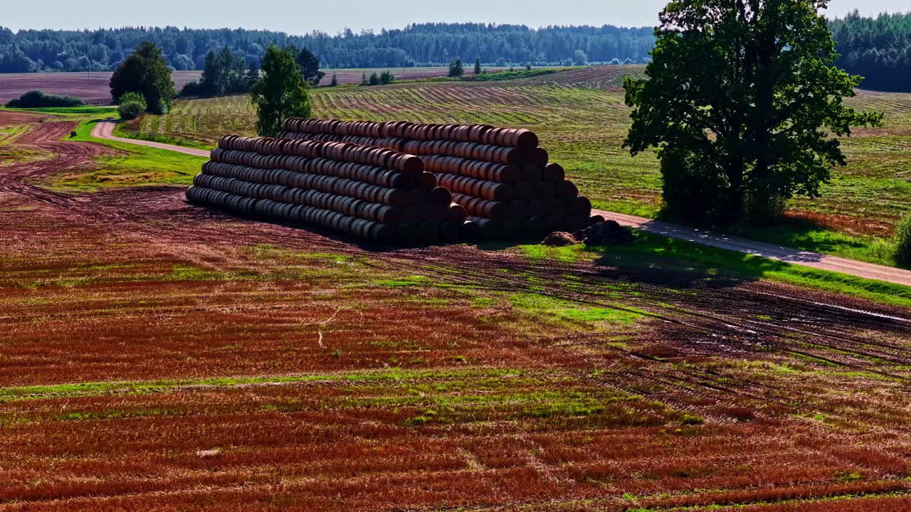 Pemandangan udara gulungan jerami yang menumpuk di ladang di lanskap pertanian pedesaan