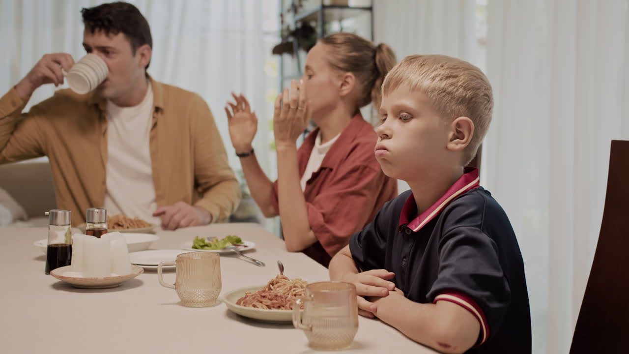 Portrait of Sad Boy Tired of His Parents Arguing during Family Dinner