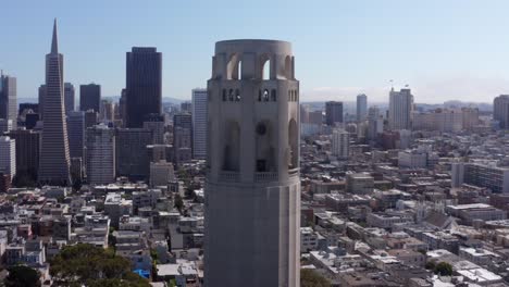 Aerial-parallax-panning-shot-of-Coit-Tower-on-top-of-Telegraph-Hill-surrounded-by-the-city-of-San-Francisco,-California