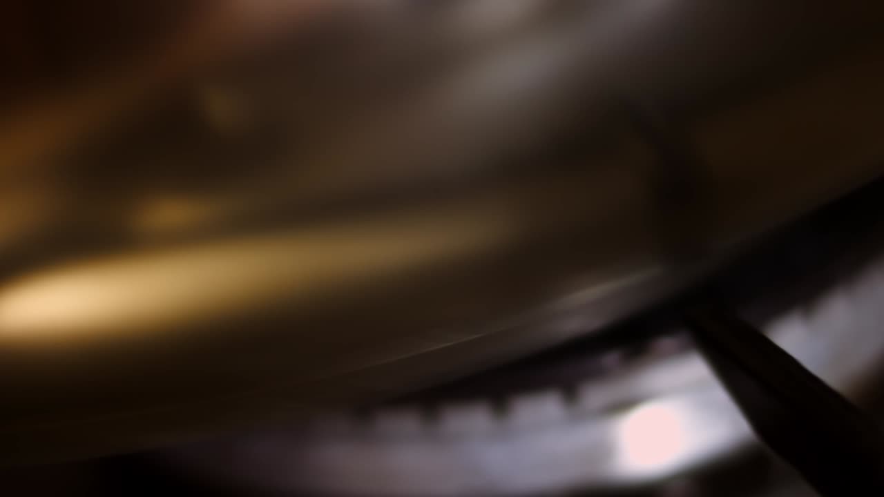 Accensione del fornello a gas su sfondo nero. Il bruciatore della cucina si accende, con un primo piano sulla fiamma. Vista ravvicinata dell'accensione del gas naturale nel bruciatore. Gas che brucia da un fornello a gas.