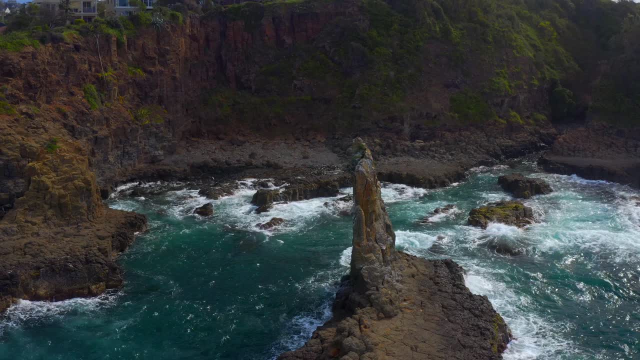 las olas espumosas chocan contra la formación de rocas volcánicas de las rocas de la catedral en kiama, nueva gales del sur, australia