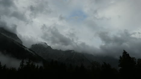 time lapse of clouds over mountain peak, dramatic stormy sky, forest in foreground, ojstrica peak in kamnisko savinjske alpe, logarska dolina, slovenia, european alps