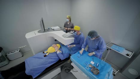corrección de la visión con láser. un paciente y un equipo de cirujanos en la sala de operaciones durante una cirugía oftalmológica