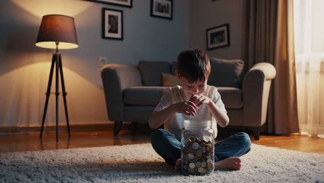 young boy saving money in a coin jar