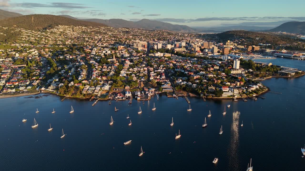 Panoramic view of Hobart city with harbour and surrounding landscapes. Orbit drone shot.