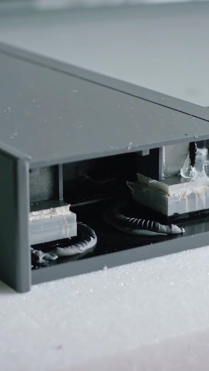 Vertical video: Panning camera revealing grey housing showing glue beads, coil on foam for check