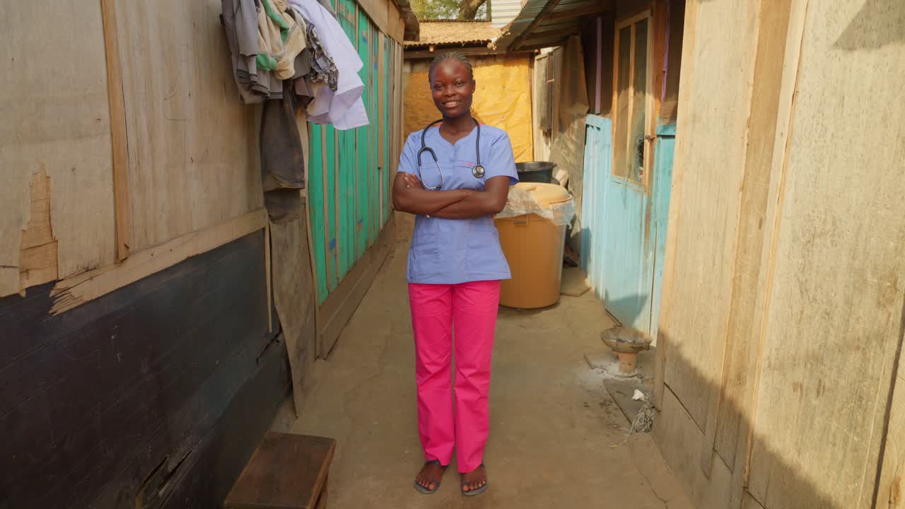 African female woman black nurse doctor crossing arms in front of camera smiling and wearing blue lab coat and stethoscope , africa healthcare concept