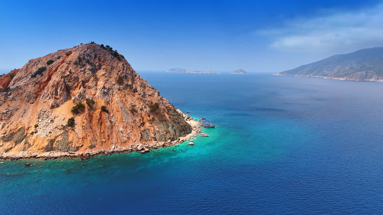 Approaching bare uninhabited island with few boats nearby. Suluada island in the Mediterranean of Turkey. Aerial view