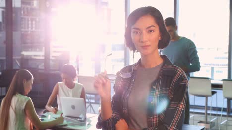 Ejecutiva-Femenina-De-Pie-Mientras-Sus-Colegas-Trabajan-En-La-Oficina-4k