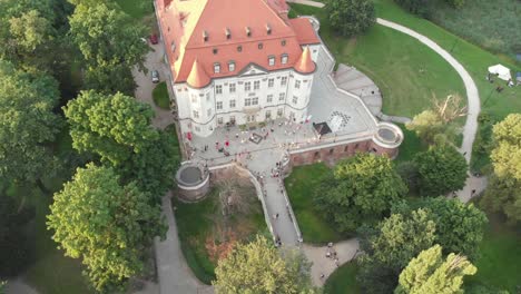 Crowd-of-people-celebrating-by-baroque-Lesnica-castle,-Wroclaw,-Poland,-bird’s-eye-view