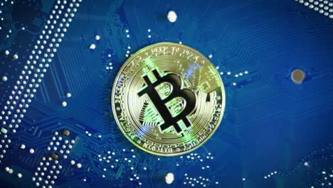 Single Bitcoin on Computer blue board rotating, Mining Bitcoins concept, Topdown shot