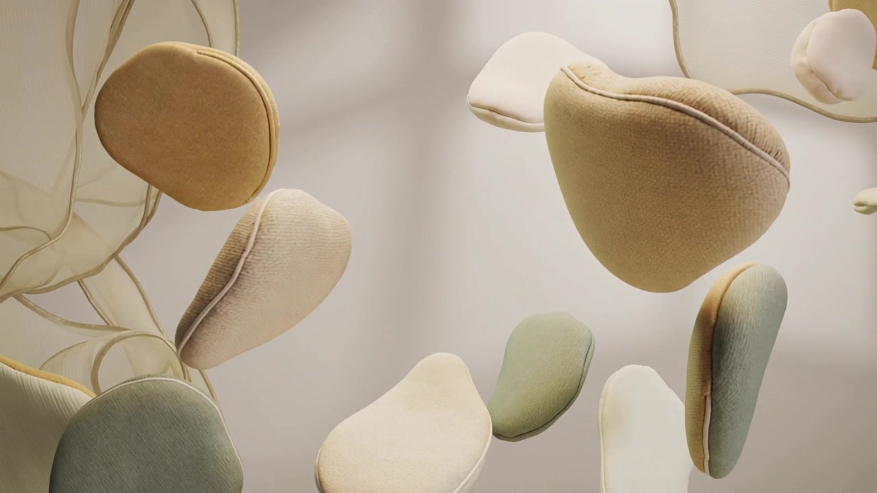 Cuscini a forma di ciottolo galleggianti che fluttuano verso l'interno e ruotano in studio, con un disegno botanico.
