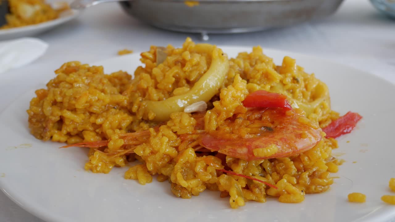 Golden, savory paella being prepared with fresh shrimp and colorful vegetables