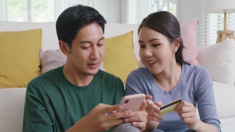 happy asian man and woman booking ticket online from retail store.