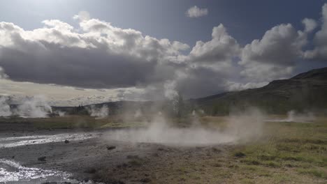 icelandic geothermal landscape, geyser erupting, clouds overhead