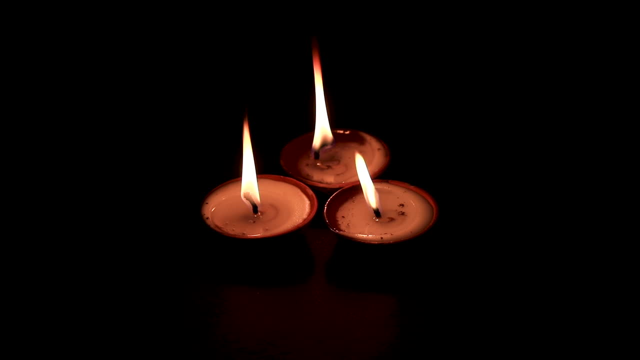 Three Butterlamp Candles burning in the dark. Traditional butterlamp glowing in the dark