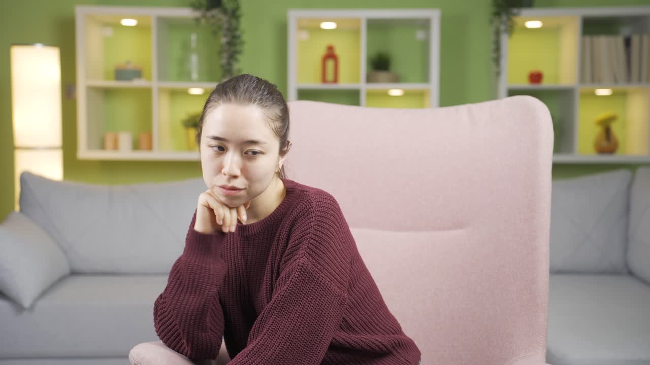 불행하고 우울한 젊은 여성이 집에서 혼자 생각하고 있습니다.