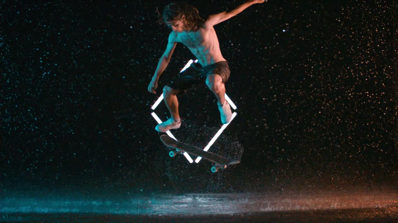 Incredible double kick flip trick by male skateboarder in slow motion rain studio