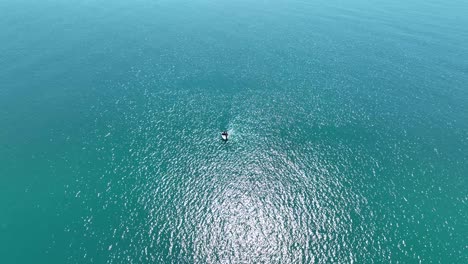 birdseye view of lone boat in middle of ocean on sunny day