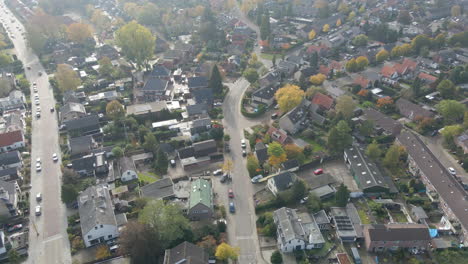 Atemberaubende-Antenne-Einer-Wunderschönen-Vorstadt-Mit-Einem-Auto,-Das-über-Die-Straße-Fährt