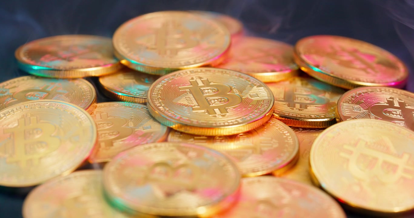 Close-up of Golden Bitcoin Coins with Smoke and Vibrant Light