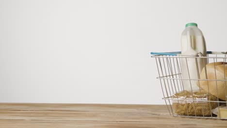 studio shot of basic food items in supermarket wire shopping basket 4