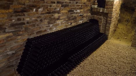 stacked wine bottles in an old stone cellar, creating a rustic and vintage atmosphere