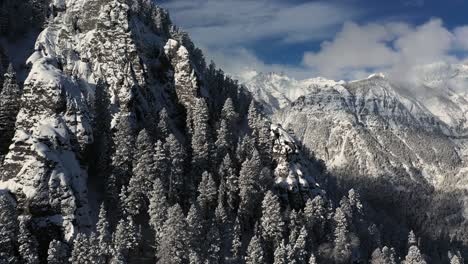snowy mountain winter landcape scenery, aerial view of steep snowcapped hills on sunny day, drone shot