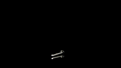 nail falling on black background 4k