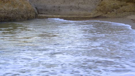 white foamy waves gently crashing on empty concrete boat ramp, filmed as stationary medium establishing shot