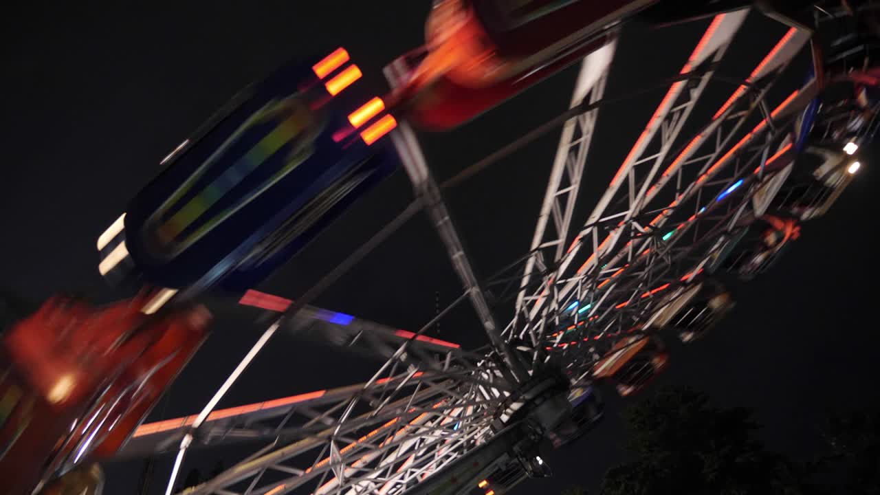swinging fair ride al anochecer tonificado en divertido parque de atracciones extremo por la noche. actividades de fin de semana.
