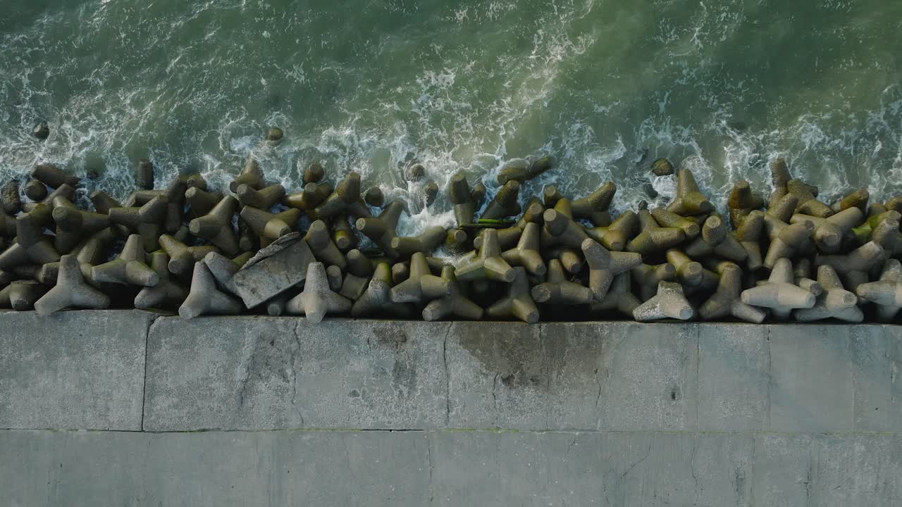 리파자 콘크리트 부두 항구, 발트해 해안선, 화창한 여름 저녁, 황금 시간 빛, 큰 파도가 튀는, 드론 버드아이 샷 상승