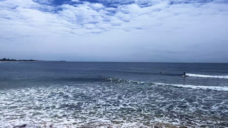 quick pan view of surfers and swimmers at moffat beach, sunshine coast queensland aus