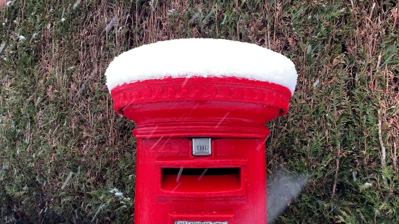 un buzón de correos rojo en invierno en navidad cubierto de nieve