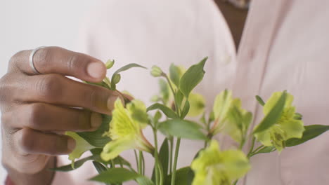 close up of man holding and touching flower bouquet