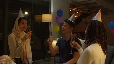 multi-cultural group of friends celebrating with party at home making a toast