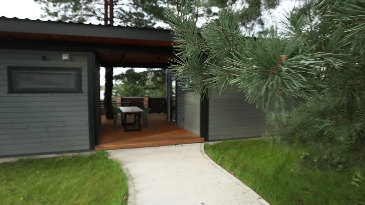 exterior de la cabaña moderna con patio y paisajismo exuberante