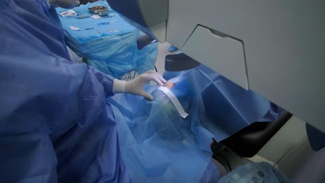 laser vision correction. a patient and team of surgeons in the operating room during ophthalmic surgery