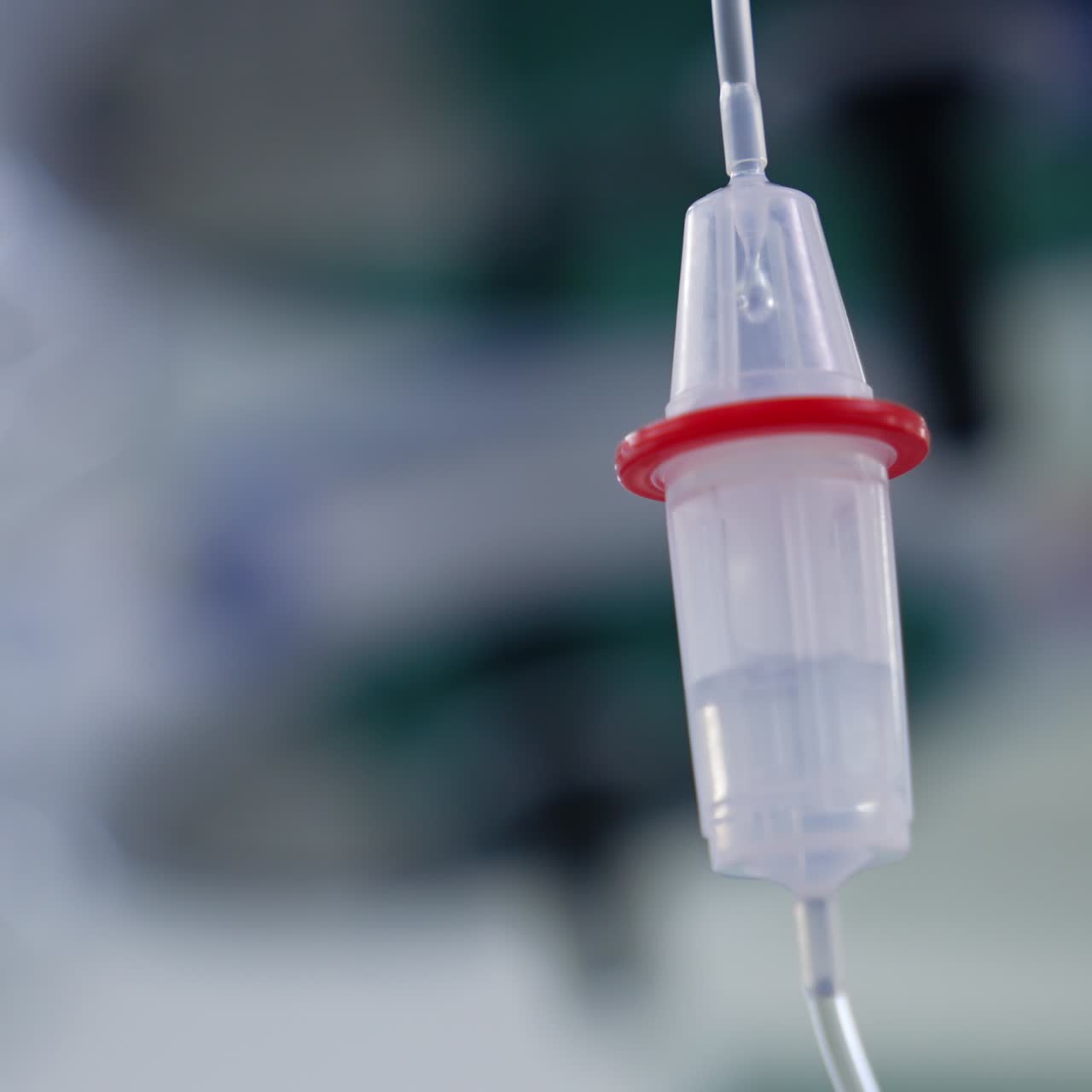 Farmaci che gocciolano rapidamente all'interno del conta-gocce. Flebo in sala operatoria. Angolazione dal basso. Sfondo sfocato